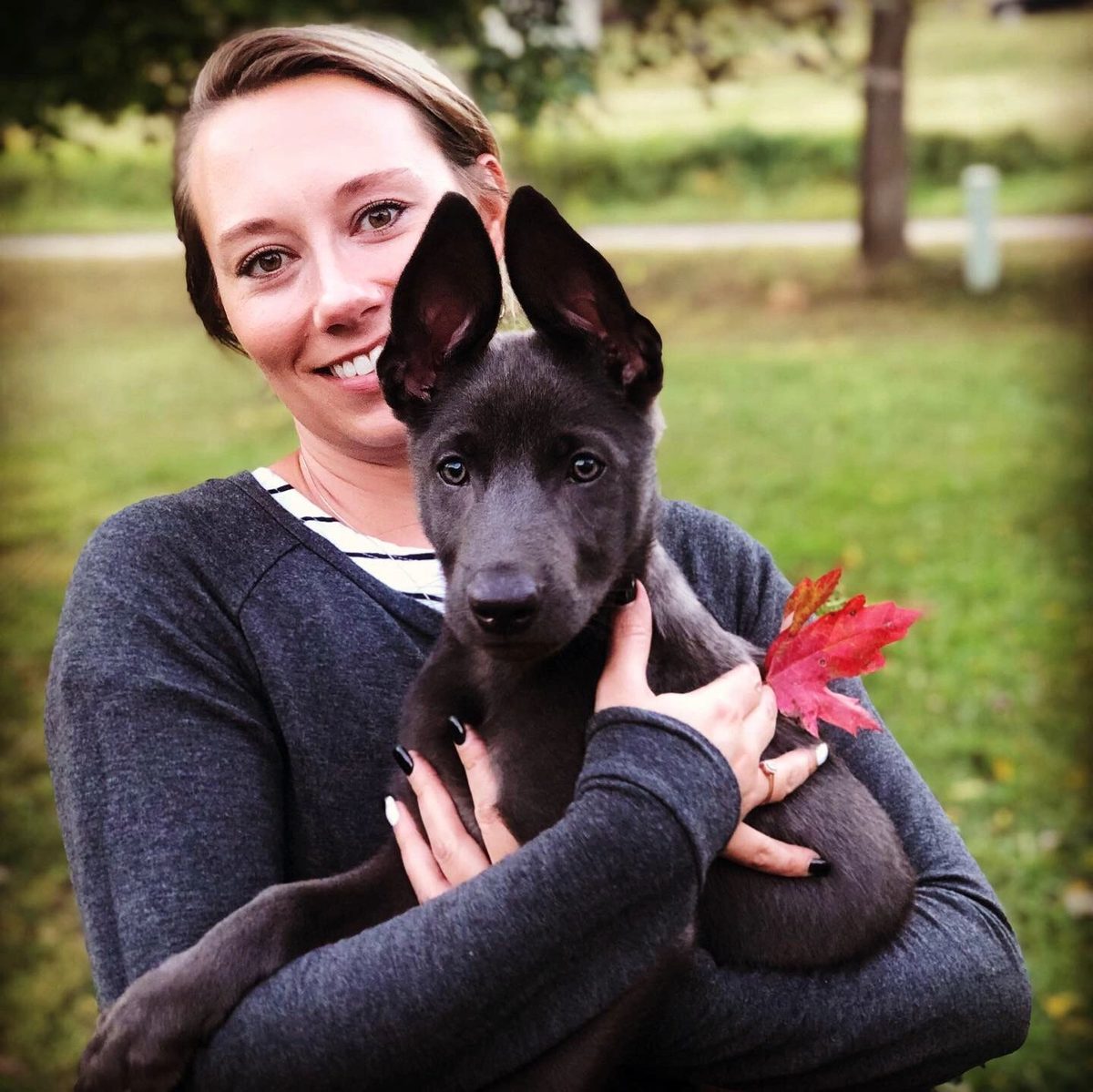 Sabrina holding the family's grey shepherd pup